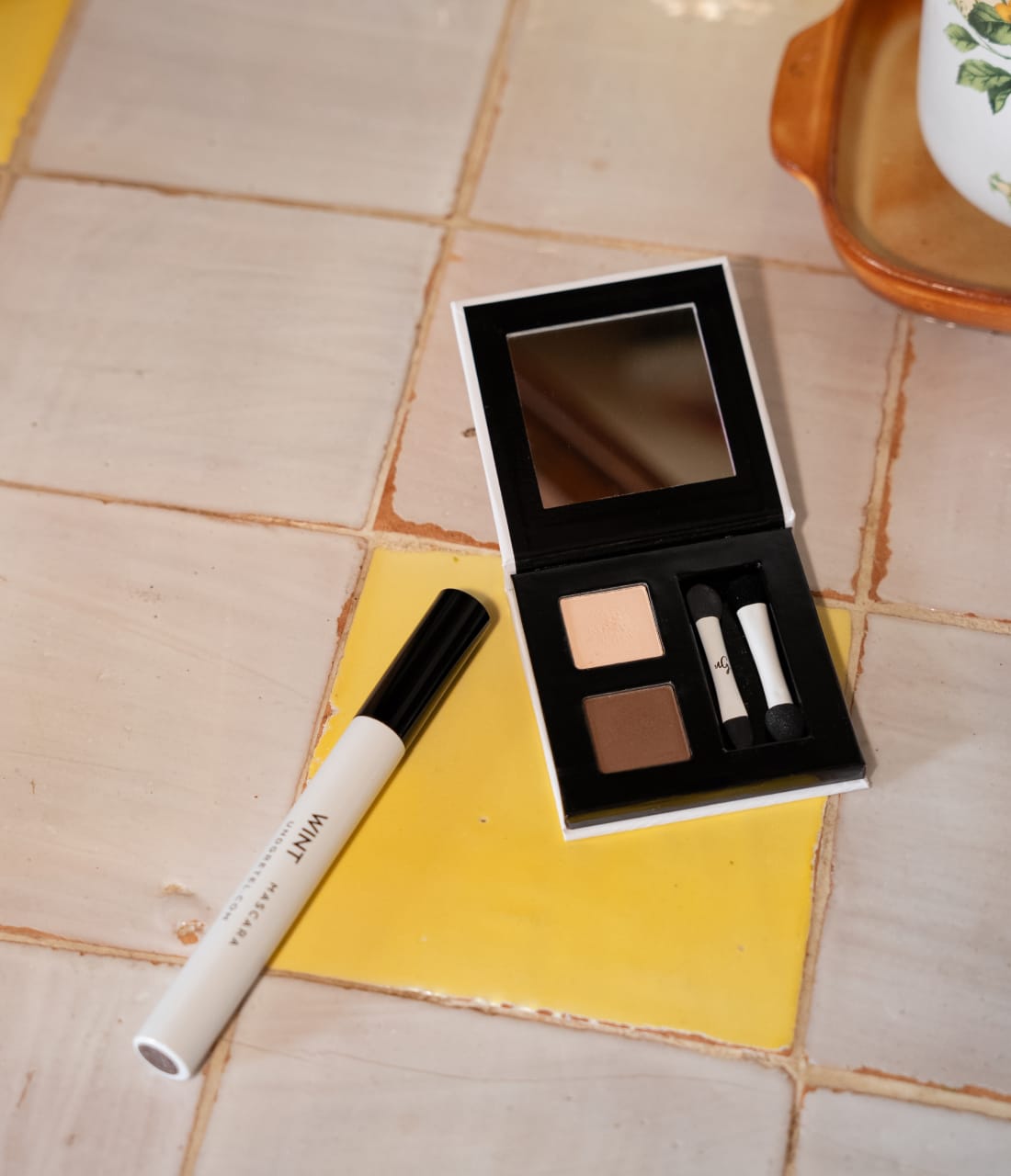 Wimperntusche und Lidschatten auf fliesen