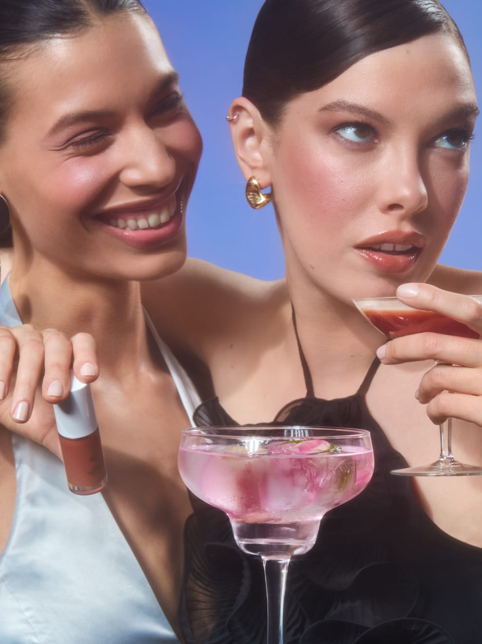 Kampagnenbild: zwei Moodels mit Cocktail im Vordergrund, PartyMood und Models tragen Gliz 01 und Gliz 04