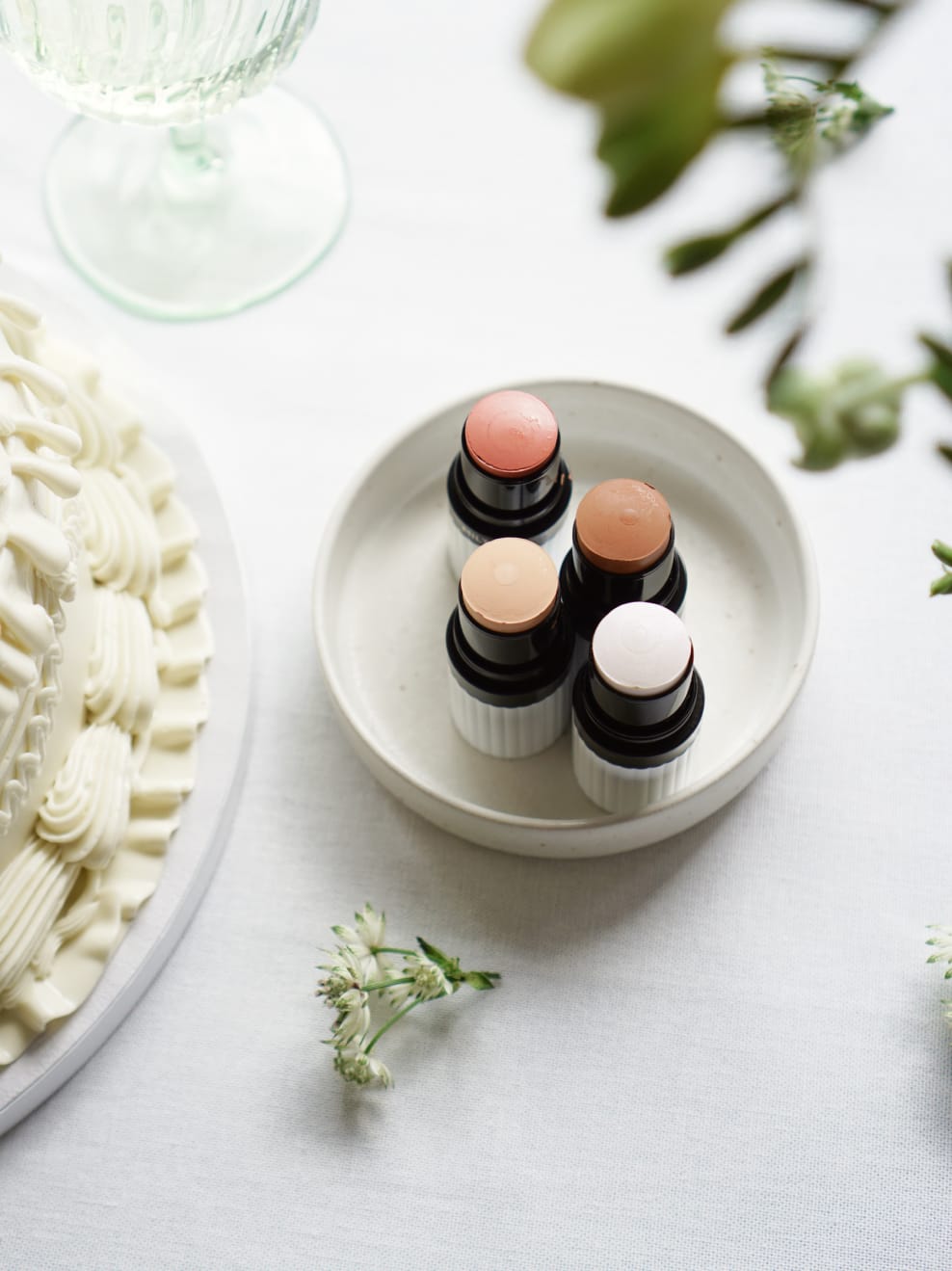 Stillbild Milte Blush, Highlighter und Foundation neben Geburtstagstorte